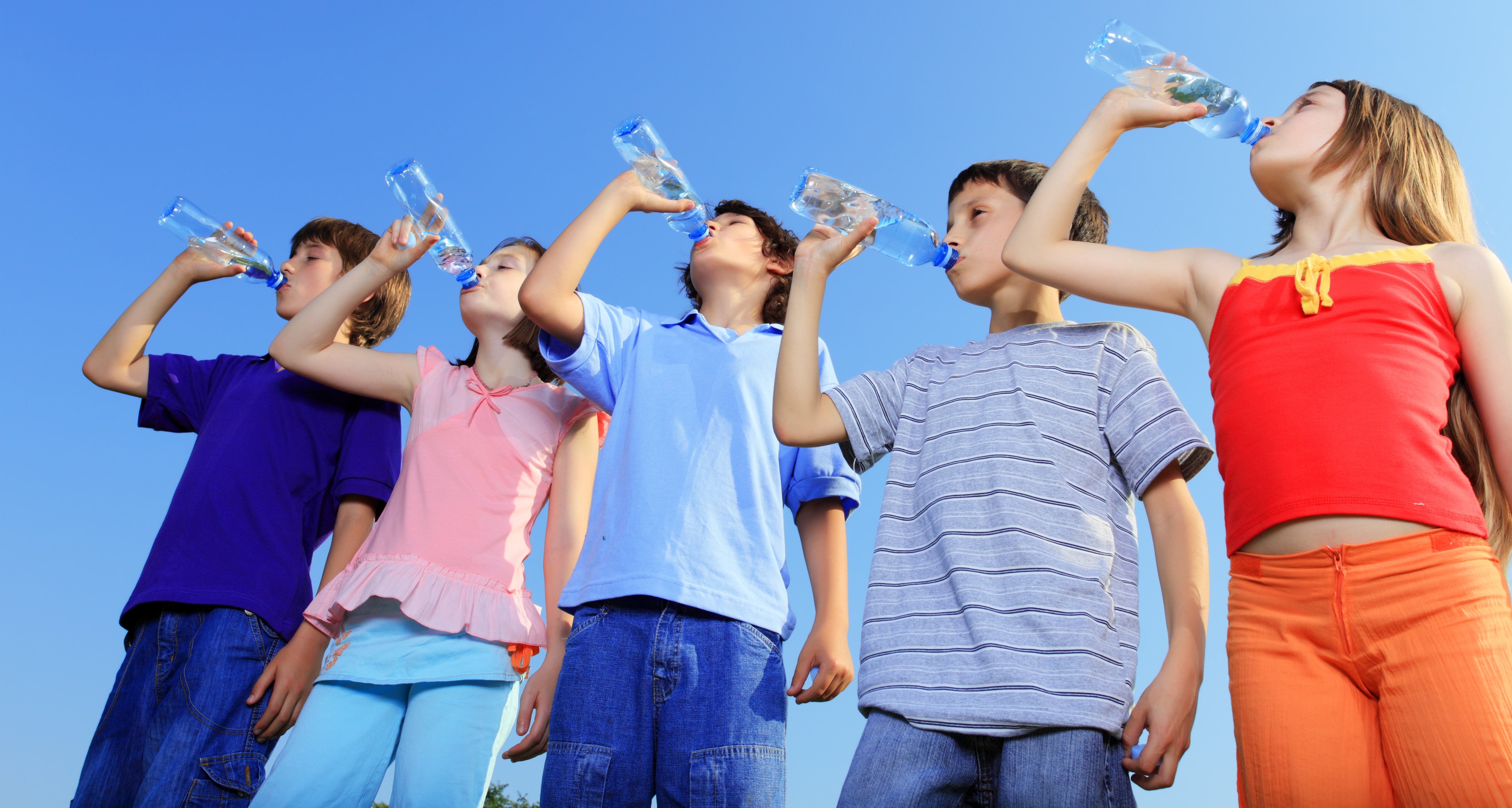kids outside drinking from water bottles